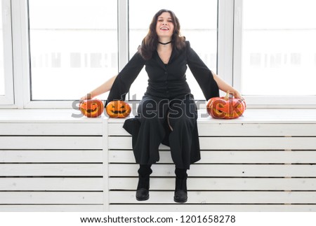Halloween and holidays concept - Witch woman with Jack O'Lantern pumpkin