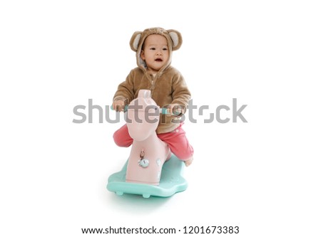     Cute baby riding a wooden horse with a white background  