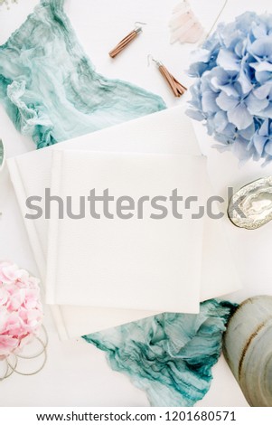 Family wedding photo album, pastel colorful hydrangea flower bouquet, turquoise blanket, decoration on white background. Flat lay, top view.