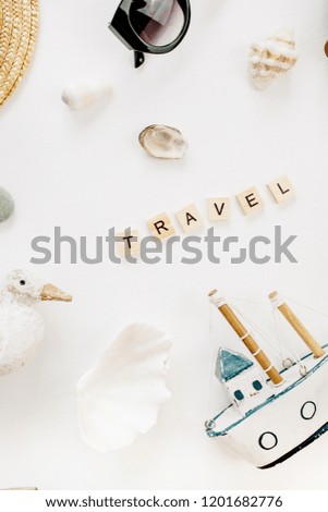 Word Travel, bird figurine, toy boat, seashells and straw hat on white background. Flat lay, top view.