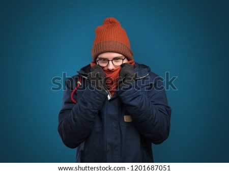 Handsome young boy freezing in warm clothing with copy space