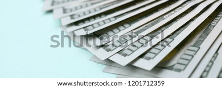 Fan of a US dollar bills of a new design lies on a light blue background