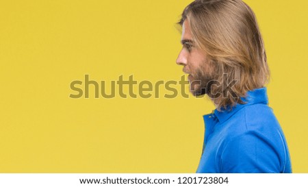 Young handsome man with long hair over isolated background looking to side, relax profile pose with natural face with confident smile.