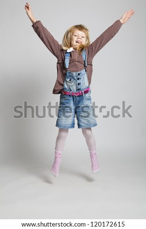 Studio portrait of happy young girl jumping