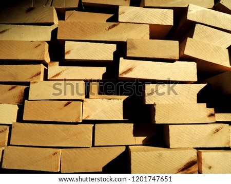 Stack of lumber wood. Close up of stacked larch planks seen from the end