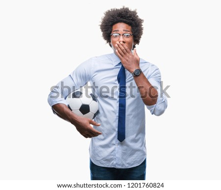 Afro american manager man holding soccer ball over isolated background cover mouth with hand shocked with shame for mistake, expression of fear, scared in silence, secret concept