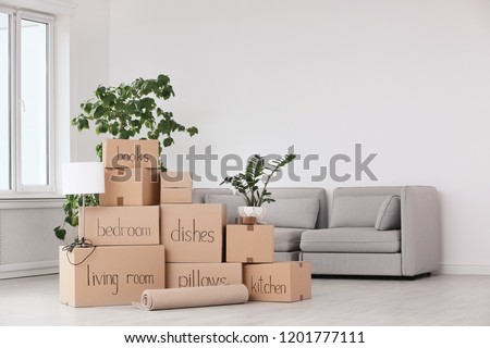 Pile of moving boxes and household stuff in living room