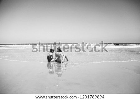 Mother and daughter having fun to spend time together on the beach at sunset