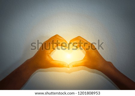 Heart shape hand on blurred background