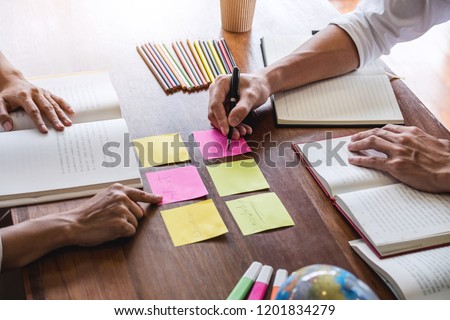 High school or college student group sitting at desk in library studying and reading, doing homework and lesson practice preparing exam to entrance, education concept. Royalty-Free Stock Photo #1201834279