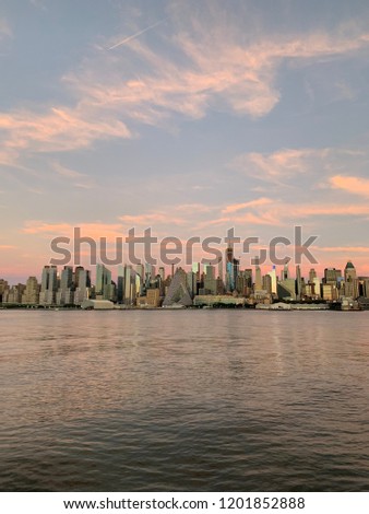 Portrait photo of New York City skyline as seen from Ferry on Hudson traveling to Port Imperial and Edgewater New Jersey at sunset