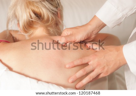 A physio gives myotherapy using trigger points on athlete woman Royalty-Free Stock Photo #120187468