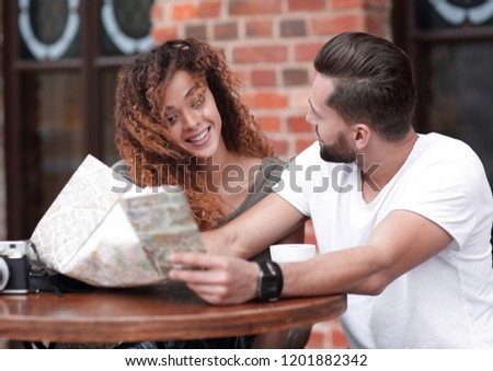 A picture of  tourists looking at map in a cafe