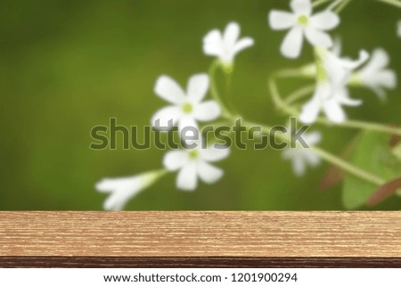 Top wood table with blurred white flower background. Copy space for your text design. Can be use montage or display show your product.