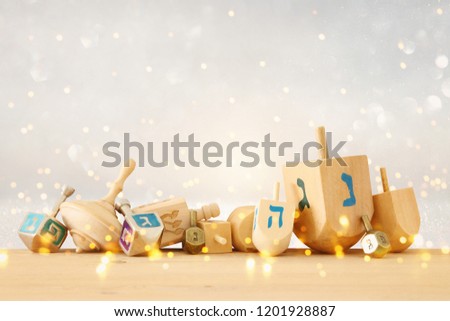 Banner of jewish holiday Hanukkah with wooden dreidels (spinning top) over glitter shiny background Royalty-Free Stock Photo #1201928887