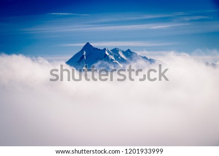 A beautiful mountain peak reaching out of the clouds on a winter day in February. Picture taken in Tignes in the Savoie department in the Rhône-Alpes region in south-eastern France