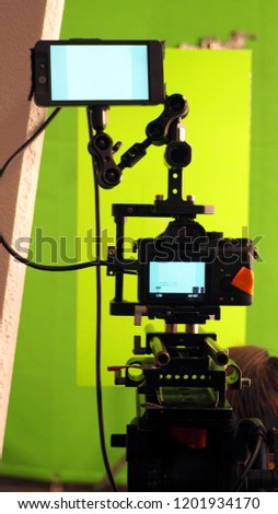 Behind the vdo camera in studio production that shooting or filming green screen background for chroma key technique in post process with professional crew teams and equipments.