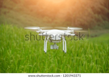 White drone quad copter with high resolution digital camera flying on autumn background.