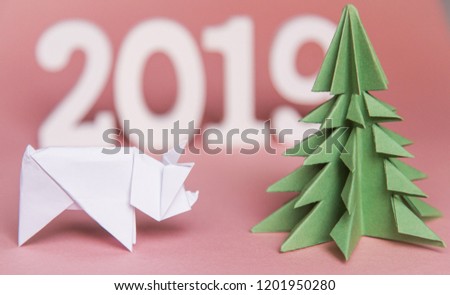 Chinese Zodiac Sign Year of Pig. green origami paper tree and white pig symbol of 2019, on a pink background, free space for text, minimalism. Happy New Year 2019 year, flatlay calendar