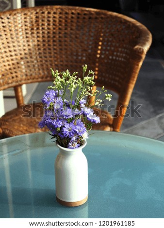 Some of beautiful blooming flowers were arranged in the white ceramic vase on the table.