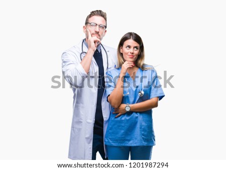 Young couple of doctor and surgeon over isolated background with hand on chin thinking about question, pensive expression. Smiling with thoughtful face. Doubt concept.