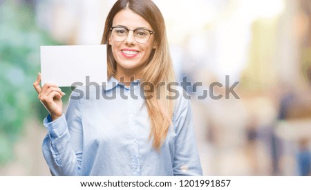 Young beautiful business woman holding blank card over isolated background with a happy face standing and smiling with a confident smile showing teeth
