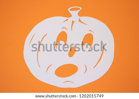 Paper halloween pumpkin on an orange background