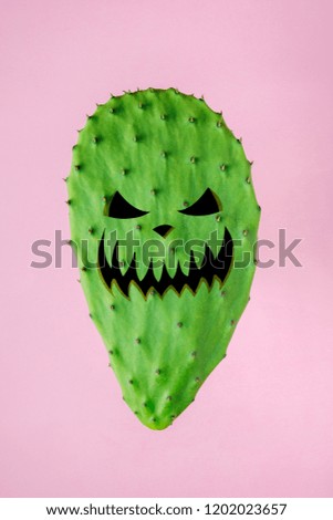 Halloween face on the green cactus on bright pink background. Creative minimal concept.
