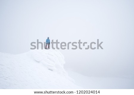 Snowy mountains in winter. Tourist photographer takes pictures with snow. Landscape in foggy weather