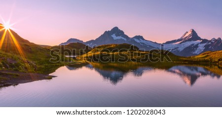 Morning reflection view on Bernese range above Bachalpsee lake. Popular tourist attraction. Location place Swiss alps, Grindelwald valley, Europe. Artistic picture.