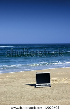 Open laptop on a beautiful beach with a great blue sky