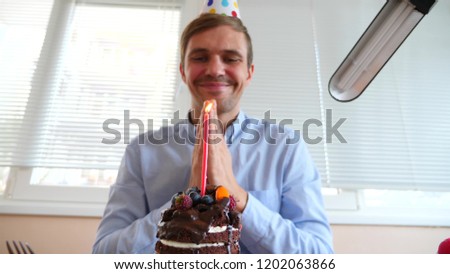 The freelancer celebrates the holiday, he sits alone at the table and eats a holiday cake.