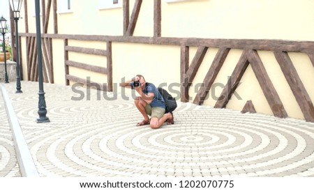 male photographer is taking pictures in the street with the help of a professional camera. copy space