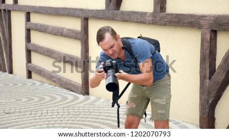 male photographer is taking pictures in the street with the help of a professional camera. copy space