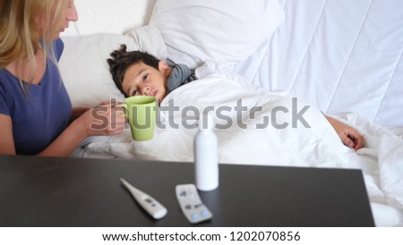 A sick baby boy was lying in bed with a fever, mama is caring for a sick son. copy space