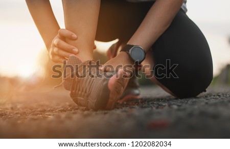 Ankle twist sprain accident in sport exercise running jogging.sprain or cramp Overtrained injured person when training exercising or running outdoors. Royalty-Free Stock Photo #1202082034