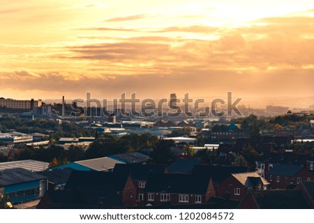 A warm orange sunset behind clouds over Sheffield, South Yorkshire, UK Royalty-Free Stock Photo #1202084572