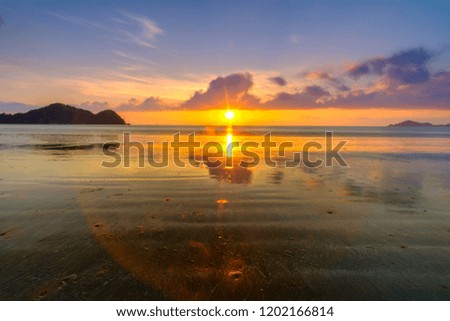 Beautiful sunrise over low tide beach with cloud reflections in Mersing, Malaysia