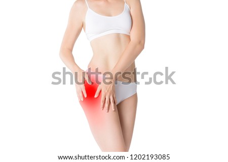 Woman with pain in thigh isolated on white background, studio shot Royalty-Free Stock Photo #1202193085
