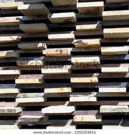 Timber ends, with the planks neatly arranged in a stack creating a pattern