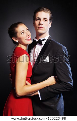 Portrait of handsome man looking at camera with beautiful woman near by looking at him