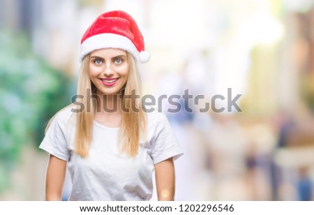 Young beautiful blonde woman christmas hat over isolated background with a happy and cool smile on face. Lucky person.