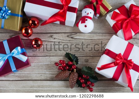 Santa, christmas presents, christmas balls and mistletoe with pine cones on wood table