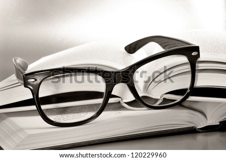 a pile of books and glasses symbolizing the concept of reading habit or studying Royalty-Free Stock Photo #120229960