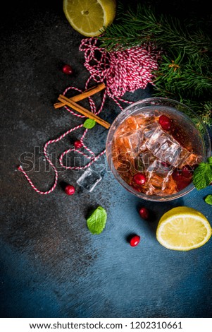 Christmas cranberry cocktail with mint and lemon, on dark blue background copy space 