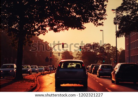 Driving in a urban road in the city at colorful orange sunrise morning