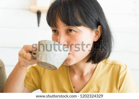 Asian business women drinking hot latte coffe in white cafe, Beautiful women