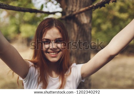 joyful woman holds up her arms in nature                        