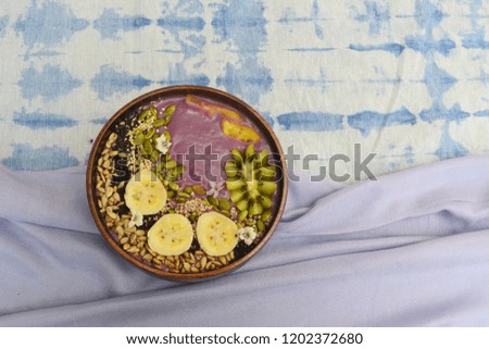 Sweet purple yam smoothie bowl with seeds  , grains and tropical fruit, healthy food concept, selective focus