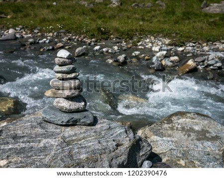 A pile of pebbles (cairn) at an Tyrolean mountain river in the Austrian Alps